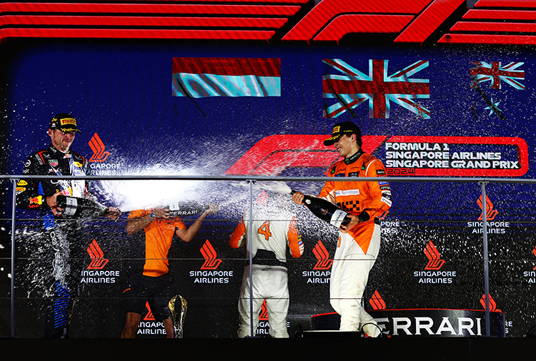 Lando Norris, Max Verstappen, and Oscar Piastri celebrate on the podium after the Singapore GP at Marina Bay Street Circuit, September 22, 2024.